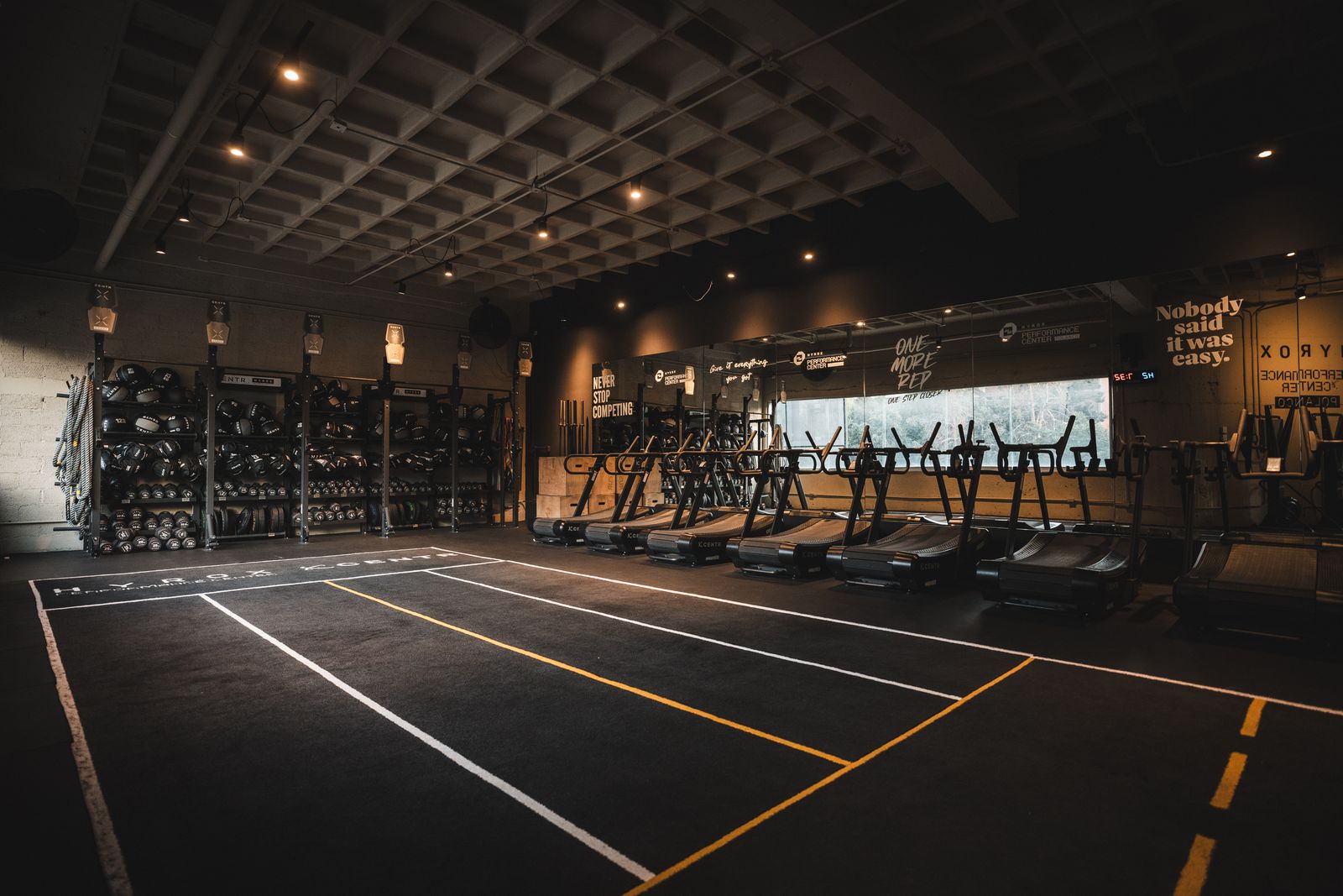 Piso de entrenamiento con carriles y racks CENTR x HYROX en el HYROX Performance Center